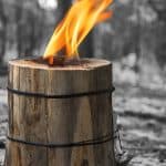 Burning Swedish candle of log on a black and white background. Handmade tourism