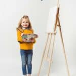 child with paint brush on a canvas 1