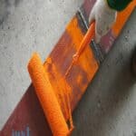 Elastomeric Paint painting metal with orange roller 1
