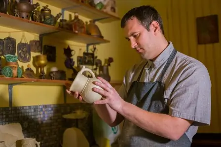 Stages of Clay 101 7 male potter examining jug