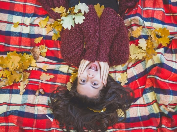 woman is lieing in leafs on blanket