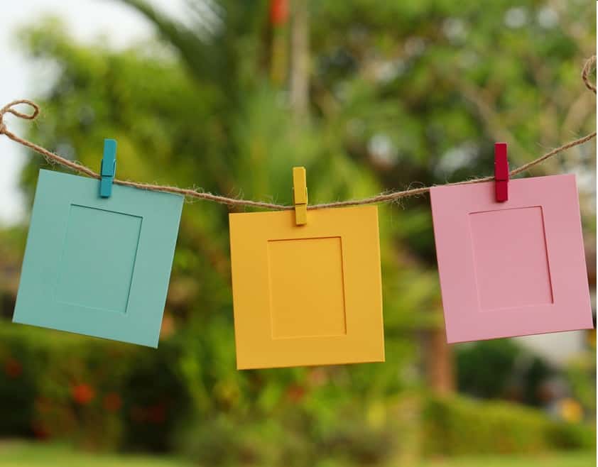 Three colorful frames hanging on rope with cloth pines