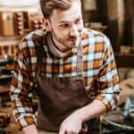 Carpenter holding chisel while carving wood