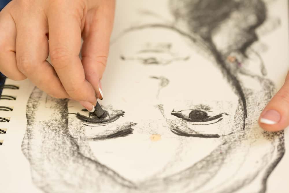 Exploring Charcoal Drawing Ideas: Unleashing Creativity through Shades of Black and Gray 11 Young girl doing a self sketch of natural charcoal
